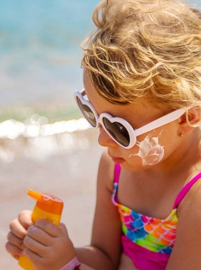Çocuk yüz yüze güneş kremi sürüyor. Seçici odaklanma. çocuk.
