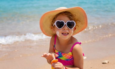 Çocuk yüz yüze güneş kremi sürüyor. Seçici odaklanma. çocuk.