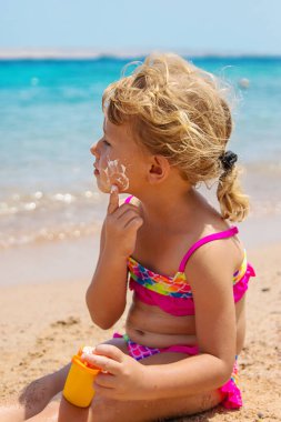 Çocuk yüz yüze güneş kremi sürüyor. Seçici odaklanma. çocuk.