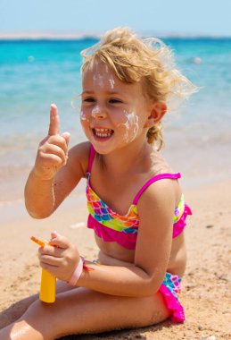 Çocuk yüz yüze güneş kremi sürüyor. Seçici odaklanma. çocuk.