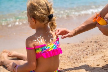 Çocuk güneş kremi sürüyor. Seçici Odaklanma Çocuğu