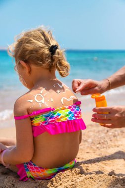 Çocuk güneş kremi sürüyor. Seçici Odaklanma Çocuğu