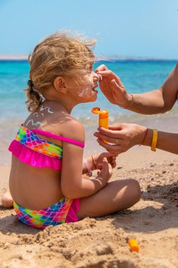 Çocuk yüz yüze güneş kremi sürüyor. Seçici odaklanma. çocuk.