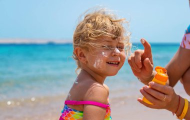 Çocuk yüz yüze güneş kremi sürüyor. Seçici odaklanma. çocuk.