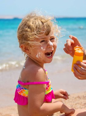 Çocuk yüz yüze güneş kremi sürüyor. Seçici odaklanma. çocuk.
