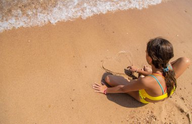 Çocuk sahilde kumla oynuyor. Seçici odaklanma. Çocuk.