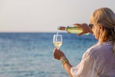 Denizde elinde bir bardak şarap olan bir kadın. Seçici odaklanma. yaz.