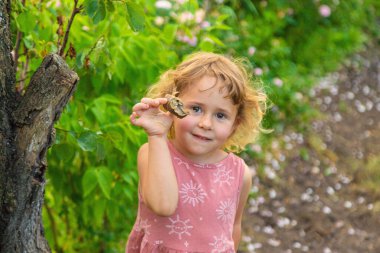 Elinde salyangoz tutan bir çocuk. Seçici odaklanma. Doğa.