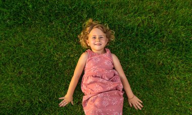 Çocuk çimlerin üzerinde yatıyor. Seçici odaklanma. Doğa.