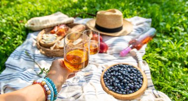 Piknikteki kadının ellerinde şarap. Seçici odaklanma. Doğa.