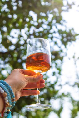 Piknikteki kadının ellerinde şarap. Seçici odaklanma. Doğa.