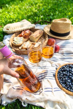 Piknikteki kadının ellerinde şarap. Seçici odaklanma. Doğa.