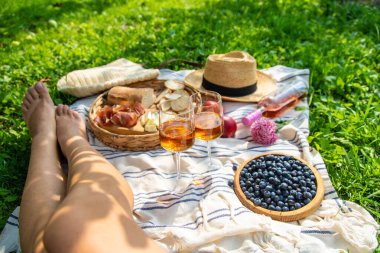 Piknikteki kadının ellerinde şarap. Seçici odaklanma. Doğa.