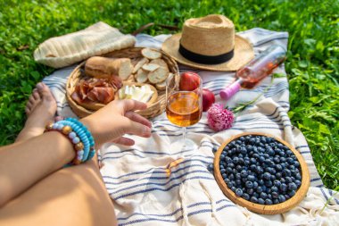 Piknikteki kadının ellerinde şarap. Seçici odaklanma. Doğa.