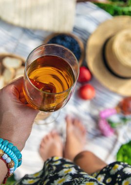 Piknikteki kadının ellerinde şarap. Seçici odaklanma. Doğa.