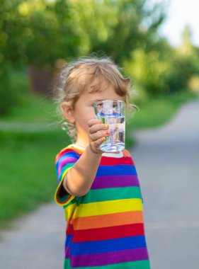 Bir çocuk bardaktan su içer. Seçici odaklanma. Çocuk.