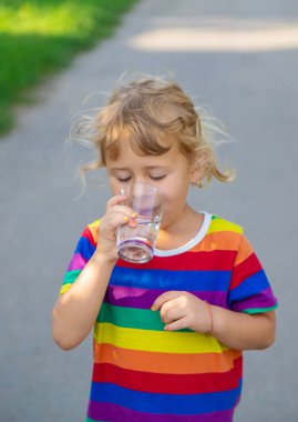 Bir çocuk bardaktan su içer. Seçici odaklanma. Çocuk.