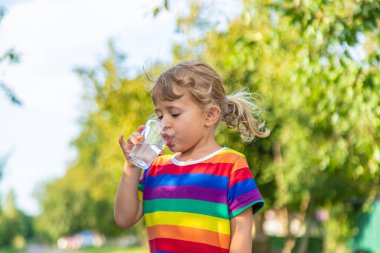 Bir çocuk bardaktan su içer. Seçici odaklanma. Çocuk.