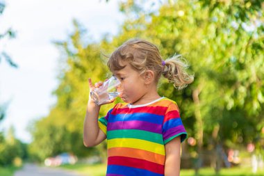 Bir çocuk bardaktan su içer. Seçici odaklanma. Çocuk.