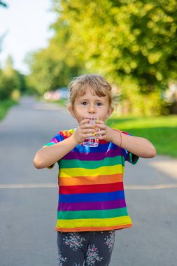 Bir çocuk bardaktan su içer. Seçici odaklanma. Çocuk.