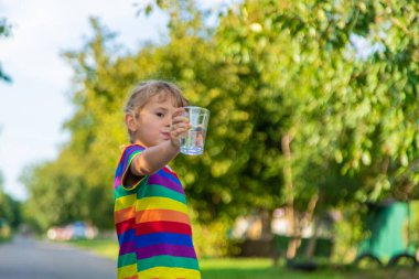 Bir çocuk bardaktan su içer. Seçici odaklanma. Çocuk.