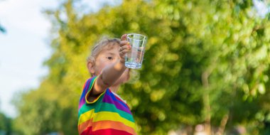 Bir çocuk bardaktan su içer. Seçici odaklanma. Çocuk.