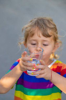 Bir çocuk bardaktan su içer. Seçici odaklanma. Çocuk.