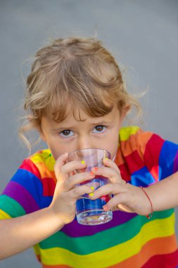 Bir çocuk bardaktan su içer. Seçici odaklanma. Çocuk.