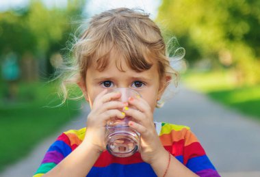 Bir çocuk bardaktan su içer. Seçici odaklanma. Çocuk.