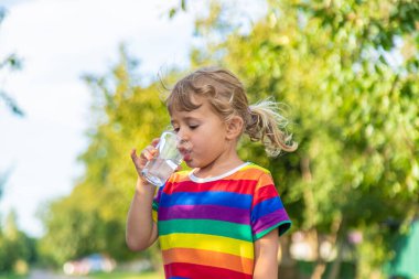 Bir çocuk bardaktan su içer. Seçici odaklanma. Çocuk.