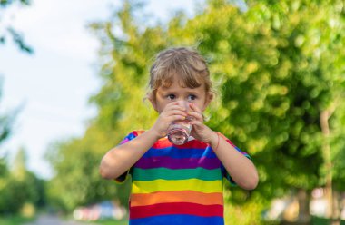 Bir çocuk bardaktan su içer. Seçici odaklanma. Çocuk.