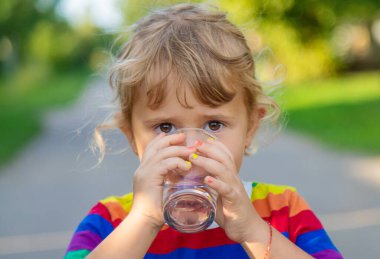 Bir çocuk bardaktan su içer. Seçici odaklanma. Çocuk.