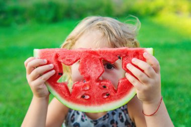 Parkta karpuz yiyen bir çocuk. Seçici odaklanma. yiyecek.