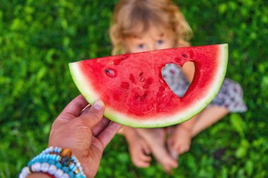 Parktaki bir çocuğun elinde bir karpuz parçası. Seçici odaklanma. yiyecek.