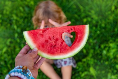 Parktaki bir çocuğun elinde bir karpuz parçası. Seçici odaklanma. yiyecek.