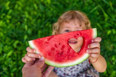 Parktaki bir çocuğun elinde bir karpuz parçası. Seçici odaklanma. yiyecek.