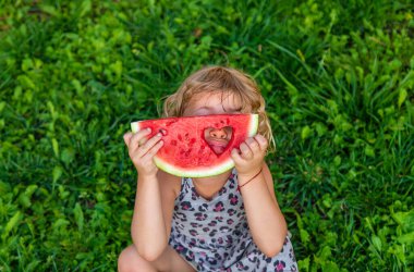 Parktaki bir çocuğun elinde bir karpuz parçası. Seçici odaklanma. yiyecek.