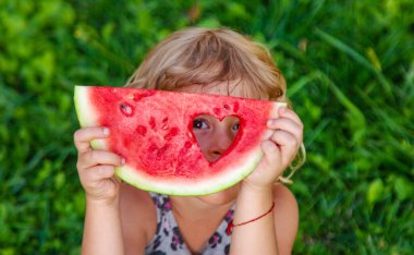 Parktaki bir çocuğun elinde bir karpuz parçası. Seçici odaklanma. yiyecek.