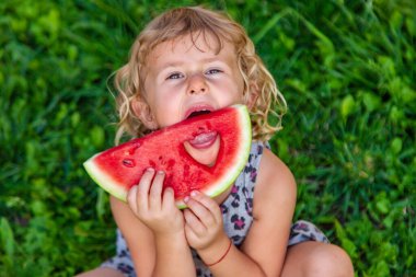 Parktaki bir çocuğun elinde bir karpuz parçası. Seçici odaklanma. yiyecek.