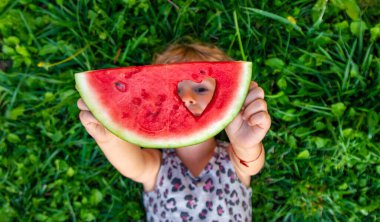 Parktaki bir çocuğun elinde bir karpuz parçası. Seçici odaklanma. yiyecek.