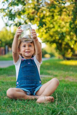 Bir çocuk doğadaki büyüteçten bakar. Seçici odaklanma. Çocuk,