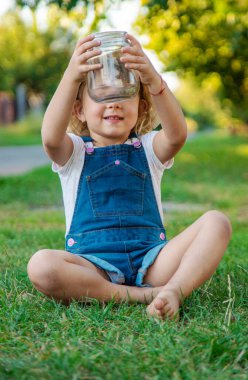 Bir çocuk doğadaki büyüteçten bakar. Seçici odaklanma. Çocuk,