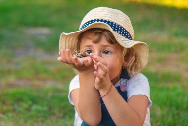 Bir çocuk doğadaki büyüteçten bakar. Seçici odaklanma. Çocuk,