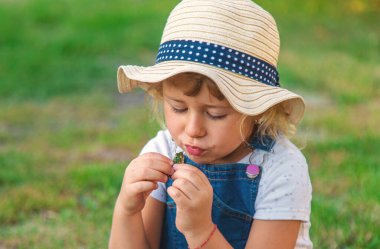 Bir çocuk doğadaki büyüteçten bakar. Seçici odaklanma. Çocuk,