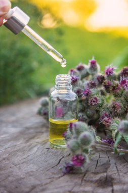 Bir şişe burdock özütü. Seçici odaklanma. Doğa.