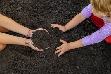 Bir çocuk elinde toprak tutuyor. Seçici odaklanma. Doğa.