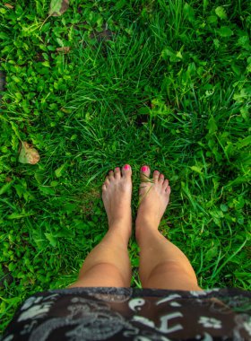 Çimlerin üzerinde kadın bacakları. Seçici odaklanma. Doğa.