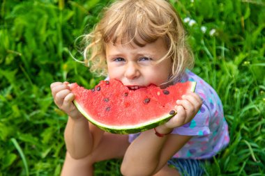 Çocuk yazın karpuz yiyor. Seçici odaklanma. Çocuk.