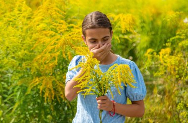 Child in ragweed flowers allergy. Selective focus. Kid. clipart