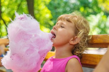 Parkta pamuk şeker yiyen bir çocuk. Seçici odaklanma. Çocuk.